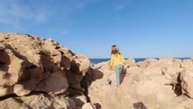 LOS CABOS MEXICO-2020: Little Girl on a Bed of Rocks by the Sea