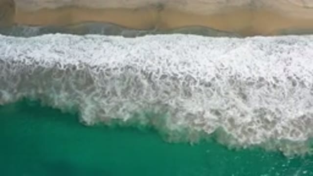 LOS CABOS MEXICO-2020: Green Water Waves with White Foam on Beach