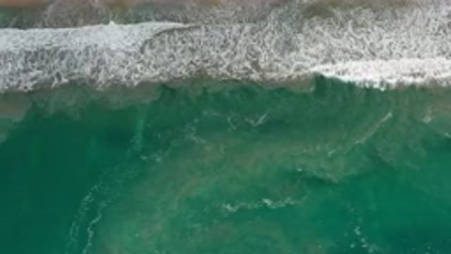 LOS CABOS MEXICO-2020: Ocean Water Breezing Through The Sand While A Person Walks