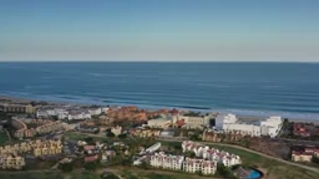 LOS CABOS MEXICO-2020: Aerial View Of City With Buildings On Ocean With Clear Sky
