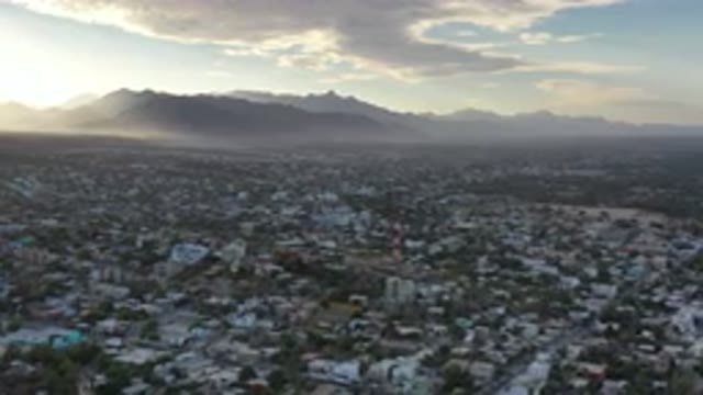 LOS CABOS MEXICO-2020: Sunlight Shines Through Clouds Over City With Mountains