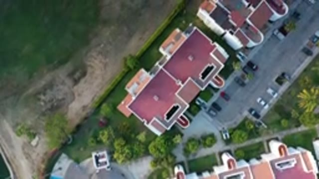 LOS CABOS MEXICO-2020: Big Buildings And Cars Parked Next To Green Grass Field