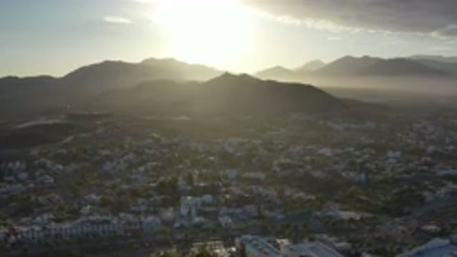 LOS CABOS MEXICO-2020: Sun Shining As It Rises Over Mountains And City