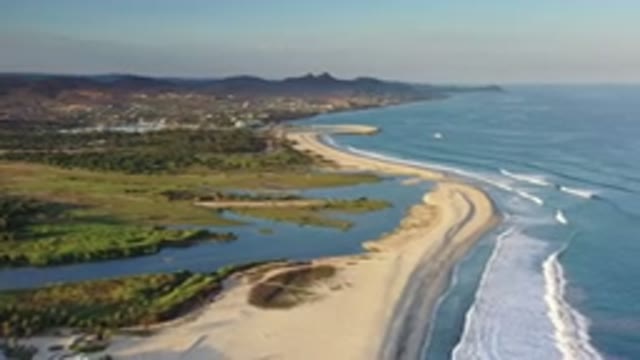 LOS CABOS MEXICO-2020: Waves Against The Sand Shoreline With A Bay That Leads To