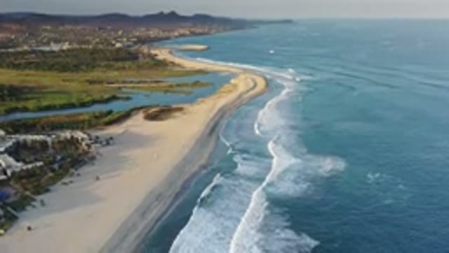 LOS CABOS MEXICO-2020: Ocean Waves Crashing on Sandy Shore with Grass and Nature