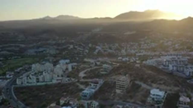 LOS CABOS MEXICO-2020: Sunset Shines Yellow Over Mountains Into A Clear Open Sky