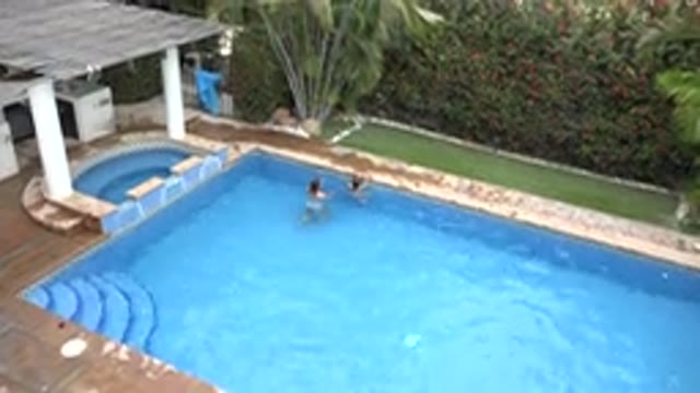 LOS CABOS MEXICO-2020: Two Girls Swim In An In Ground Swimming Pool With Blue