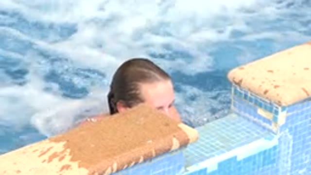 LOS CABOS MEXICO-2020: Woman Hanging Onto Side Of Hot Tub And Pushes