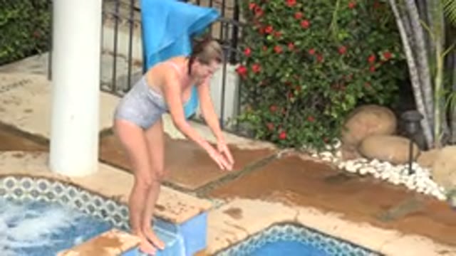 LOS CABOS MEXICO-2020: Woman Jumping in Swimming Pool with Dog Nearby