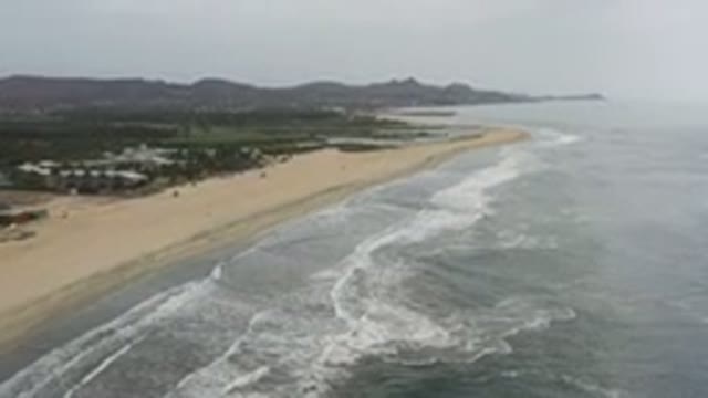 LOS CABOS MEXICO-2020: A Beach From A Bird's Eye View With Water Rushing Up The
