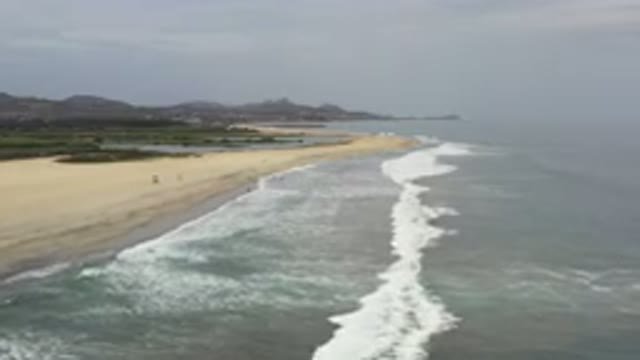 LOS CABOS MEXICO-2020: Waves Crash Onto Shoreline Of Beach On A Cloudy Day