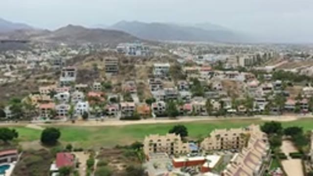 LOS CABOS MEXICO-2020: Drone Flying Above City With Green Grass Fields Next To