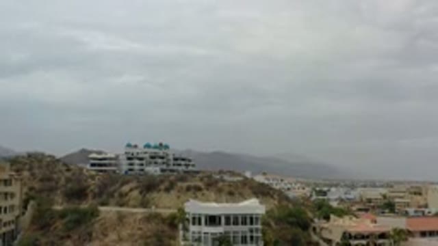 LOS CABOS MEXICO-2020: White Building On Side Of Hill With Gray Clouds Overhead