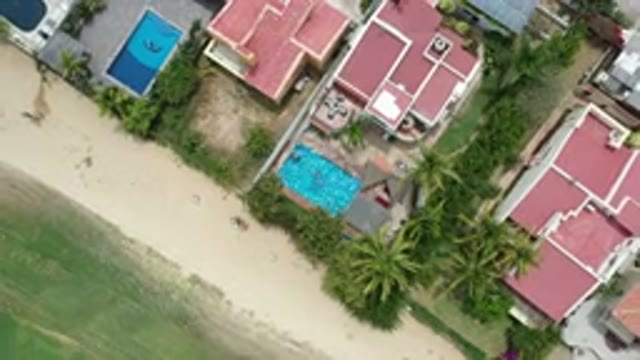 LOS CABOS MEXICO-2020: Aerial View Of House With Red Roof And Pool Next To Sandy Area
