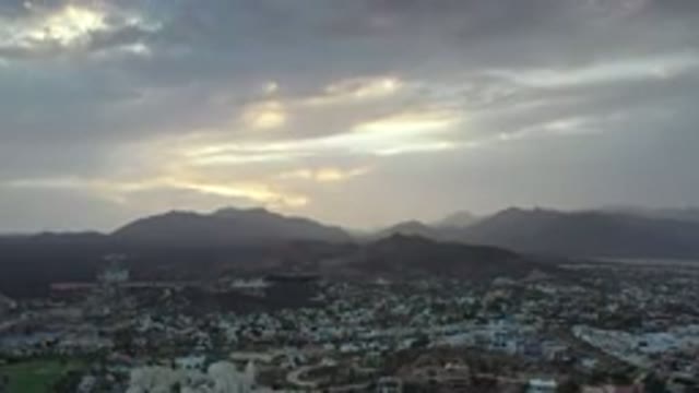 LOS CABOS MEXICO-2020: Sun Setting Through Dense Clouds In The Evening Mountains