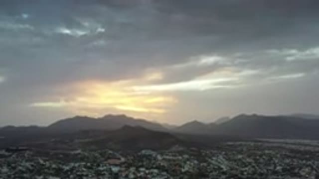 LOS CABOS MEXICO-2020: Mountain-Capped Sunset on the Horizon Near a City Tucked