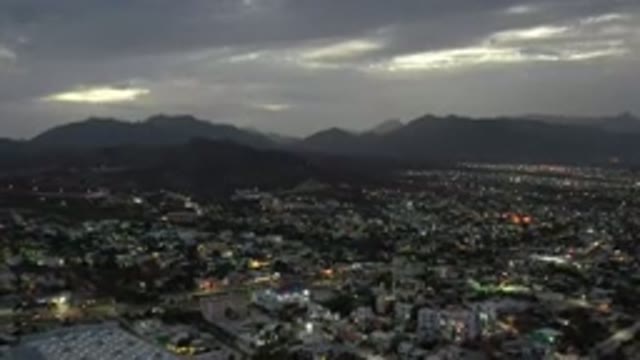 LOS CABOS MEXICO-2020: City Lights Up As The Sun Goes Down In A Cloudy Sky With