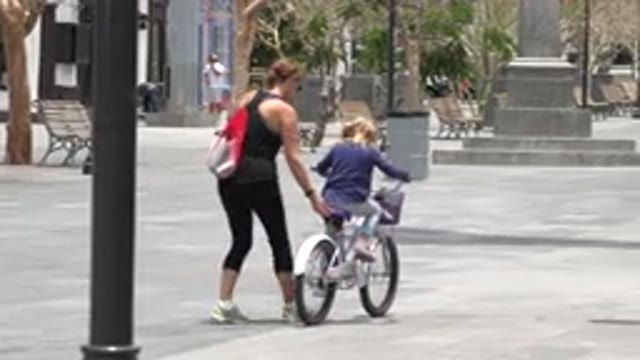 LOS CABOS MEXICO-2020: Mother Teaches Child to Ride Bicycle