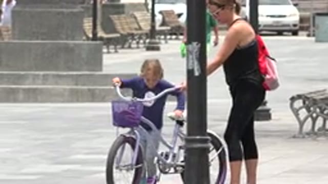 LOS CABOS MEXICO-2020: Mother Helps Daughter Hop On Purple And White Bike For