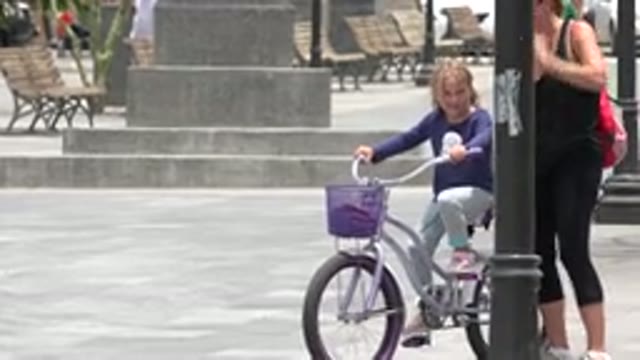LOS CABOS MEXICO-2020: A Little Girl Learning to Ride a Bicycle with Mother Supporting