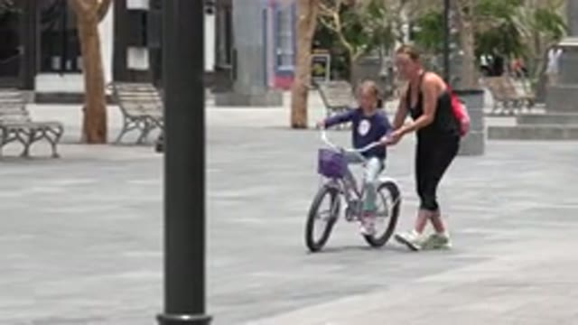 LOS CABOS MEXICO-2020: Mother Teaching Her Child To Ride A Bike For The First Time