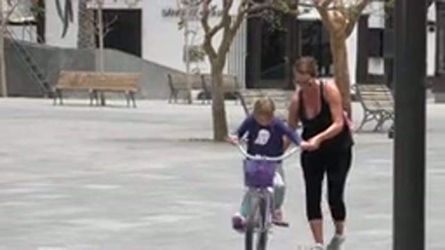 LOS CABOS MEXICO-2020: Mother Struggling To Help Her Young Daughter Learn To Ride Bike