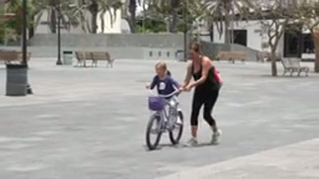 LOS CABOS MEXICO-2020: Mom Helping Her Young Child Ride Bicycle While Having Fun