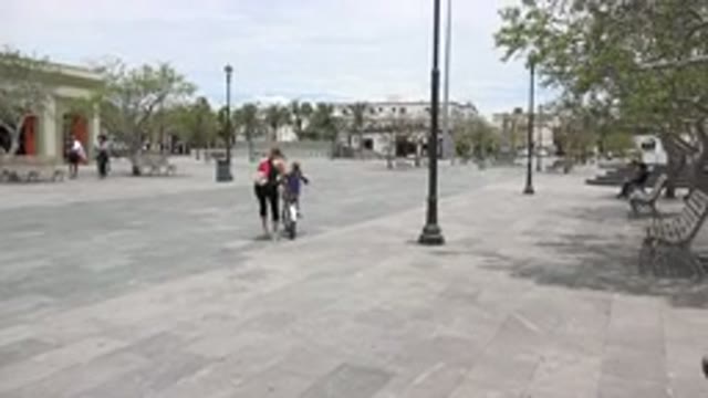 LOS CABOS MEXICO-2020: Child Learning to Ride Bike in Sunny Courtyard