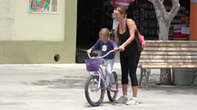 LOS CABOS MEXICO-2020: A Little Girl Trying To Ride A Bicycle With Her Mother