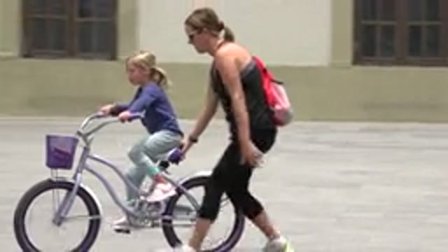 LOS CABOS MEXICO-2020: Mother Assisting Child in Learning to Ride a Bike