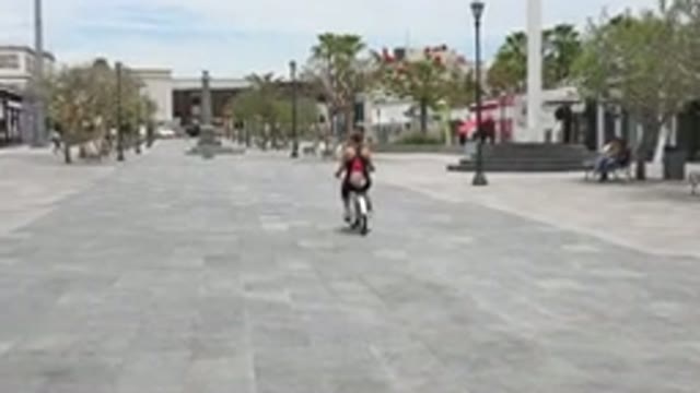 LOS CABOS MEXICO-2020: Woman Rides In Circles On Her Bicycle Through Small Town