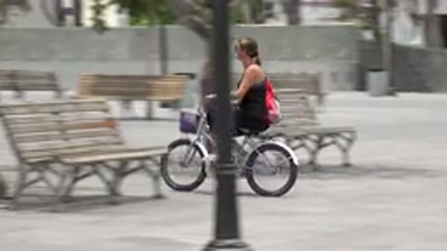 LOS CABOS MEXICO-2020: A Woman In Black Clothes Cycling To The Store On A