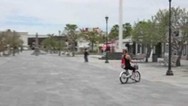 LOS CABOS MEXICO-2020: Child Gently Jogs Chasing Adult Riding Purple Bike
