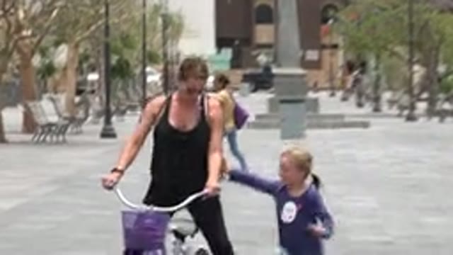 LOS CABOS MEXICO-2020: A Woman Cycling and Little Girl Trying to Catch Her