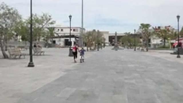LOS CABOS MEXICO-2020: Mother Running Beside Daughter Teaching Her To Ride A Bicycle