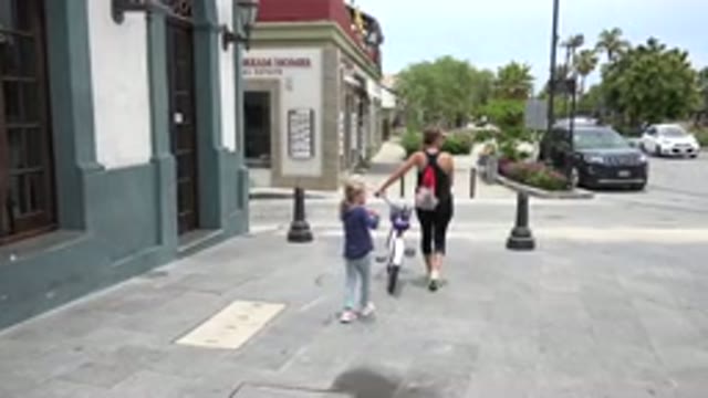 LOS CABOS MEXICO-2020: Mother Walks With A Bike While Her Child Follows Behind