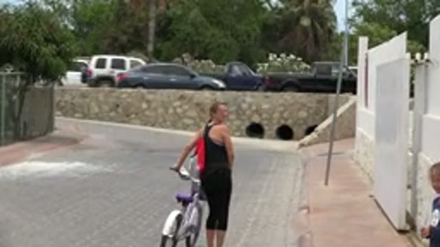 LOS CABOS MEXICO-2020: Woman Walking With Bike To Cobblestone Bridge As Car Passes