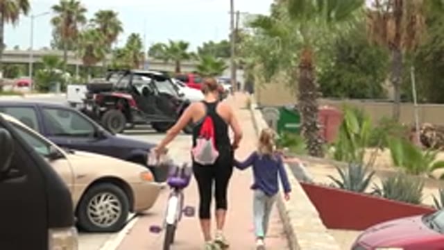 LOS CABOS MEXICO-2020: Mother And Child Walk Along The Sidewalk