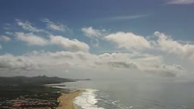 LOS CABOS MEXICO-2020: Panning Over Shore Blue Sky Partly Cloudy Beach And Mountains