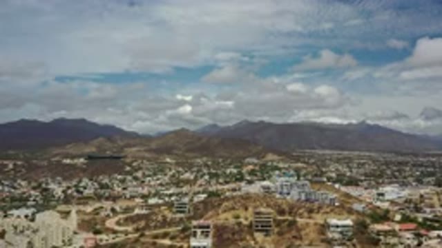 LOS CABOS MEXICO-2020: Aerial View Approaching Low Hills Over Moderately Developed Area