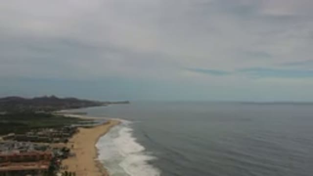 LOS CABOS MEXICO-2020: Waves Washing Onto Sandy Beach From A Deep Blue Ocean On