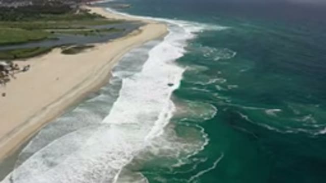 LOS CABOS MEXICO-2020: Beautiful Ocean Waves Crash And Ripple Over A Sandy Beach