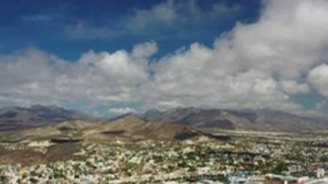 LOS CABOS MEXICO-2020: Shot Of A Desert City Panning Up To A Blue Sky Full Of Fluffy Clouds