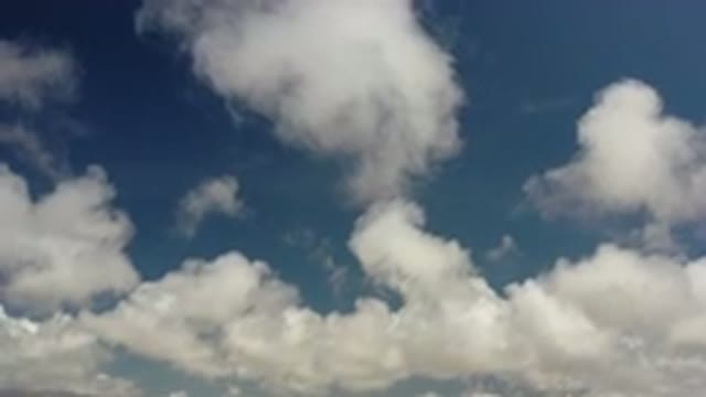 LOS CABOS MEXICO-2020: Moving White Fluffy Clouds High Above Baby Blue Daytime