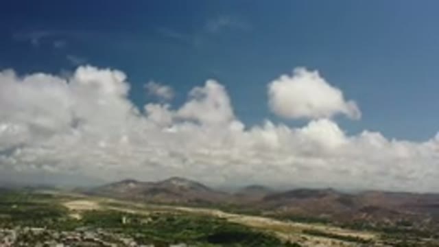 LOS CABOS MEXICO-2020: Rolling Clouds Over A Mountain Landscape With A City In View