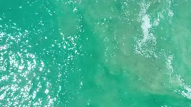LOS CABOS MEXICO-2020: Bird's Eye View Of Moving Green Ocean Water With Small White Froth