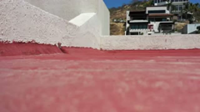 LOS CABOS MEXICO-2020: Red Pavement With A Building In The Background That Sits
