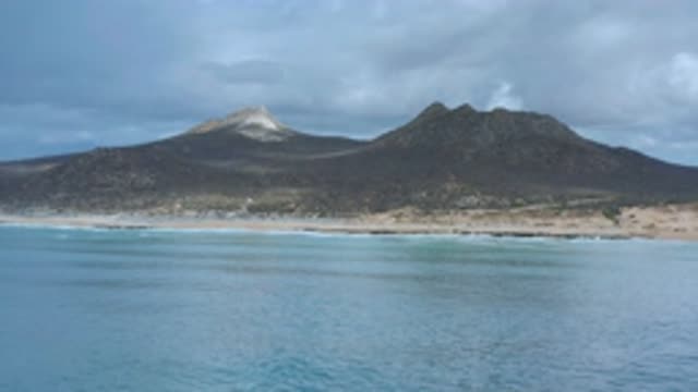 LOS CABOS MEXICO-2020: Looking From The Ocean A Mountain Shows Its White Peak