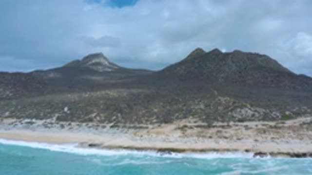 LOS CABOS MEXICO-2020: Plant Covered Mountains Overlook The Shoreline Where The
