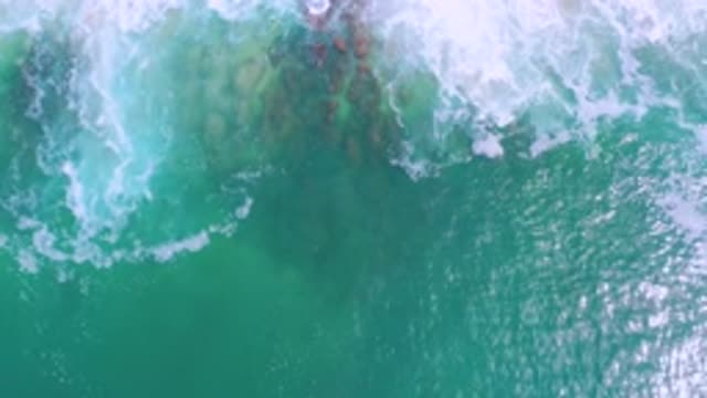 LOS CABOS MEXICO-2020: White Foam Waves Crash Next To Series Of Red Stones At